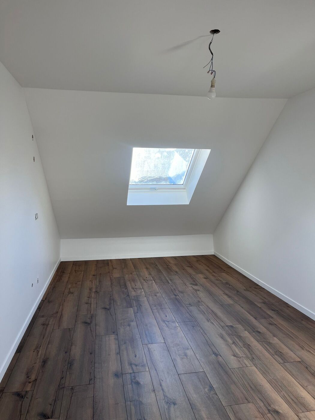 Combles aménagés — chambre livrée avec fenêtre de toit et parquet