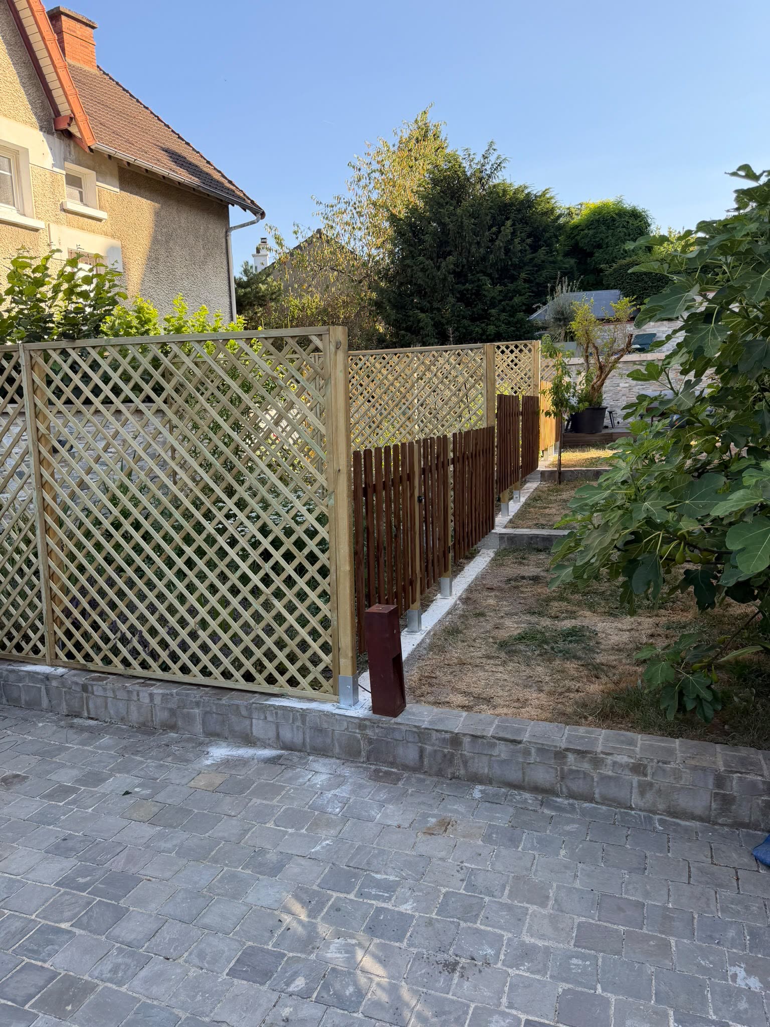 Clôture bois sur longrine béton et allée pavée